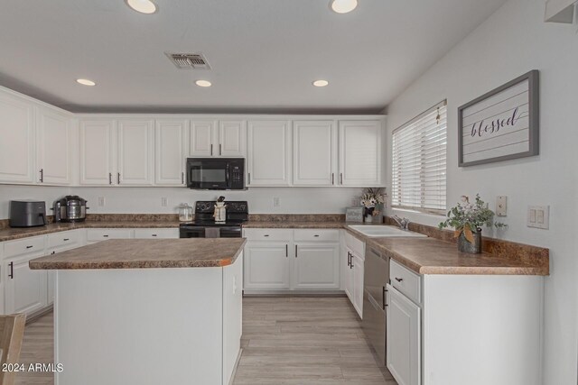 kitchen featuring white cabinets, light wood-type flooring, sink, black appliances, and a kitchen island