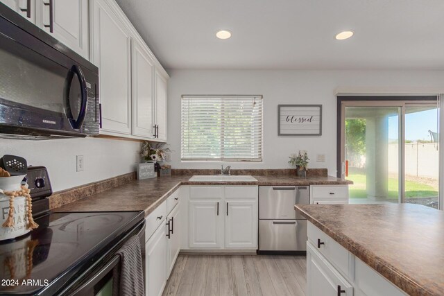 kitchen featuring light hardwood / wood-style flooring, sink, range with electric cooktop, and white cabinets