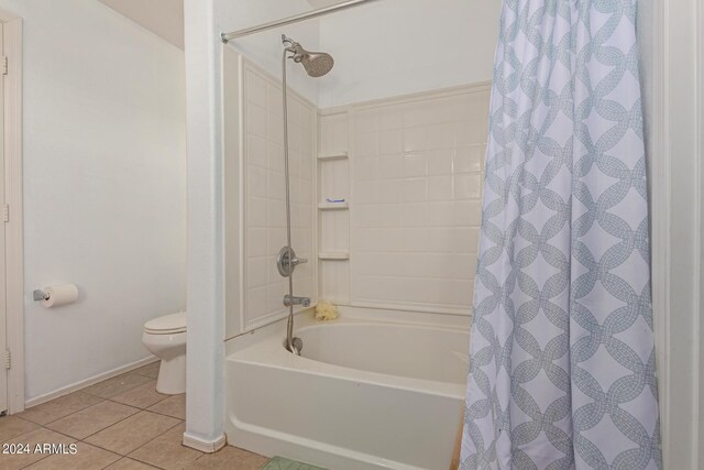 bathroom featuring tile patterned flooring, toilet, and shower / tub combo