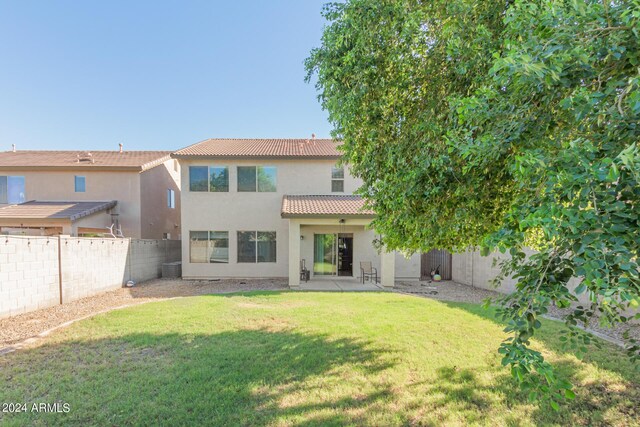 rear view of property with a yard and a patio area