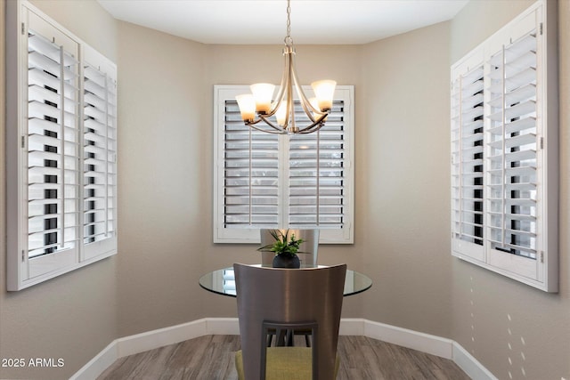 dining area with hardwood / wood-style floors and a notable chandelier