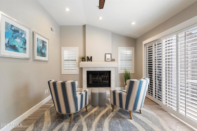 sitting room featuring hardwood / wood-style floors, ceiling fan, a fireplace, and vaulted ceiling