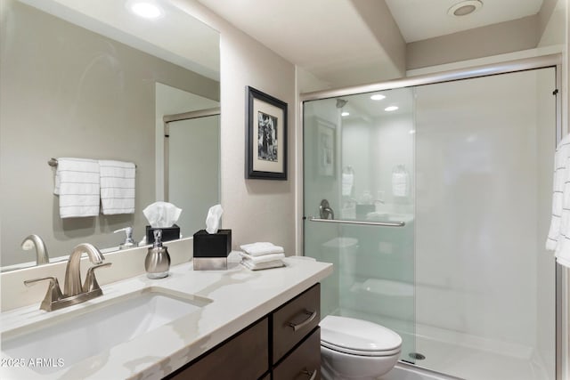 bathroom with vanity, a shower with shower door, and toilet