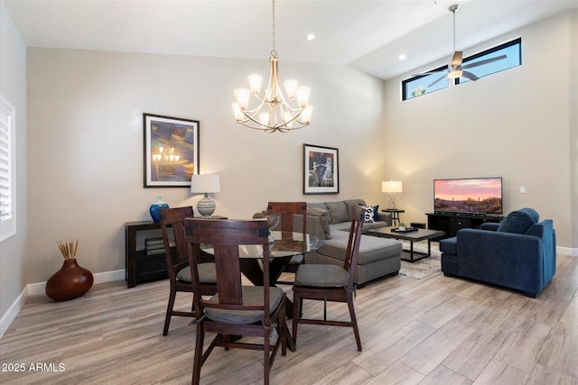 dining area featuring lofted ceiling, light hardwood / wood-style floors, and ceiling fan with notable chandelier