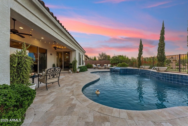 7511 S Parkcrest St, Gilbert, AZ 85298 - pool at dusk featuring a ceiling fan, a fenced backyard, a patio area, and a pool with connected hot tub