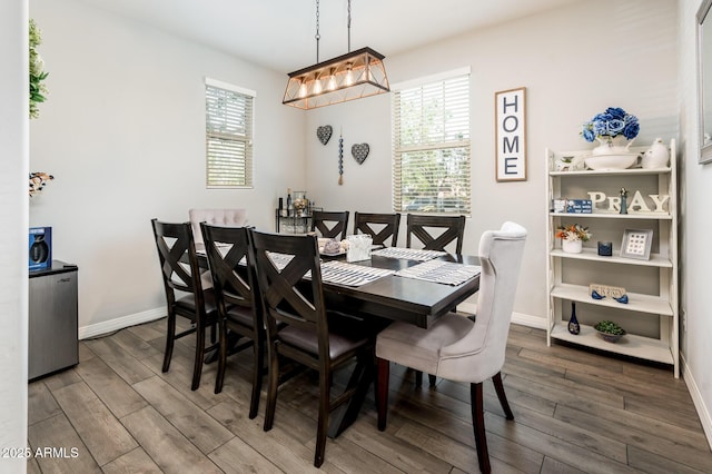 dining space featuring wood finished floors and baseboards