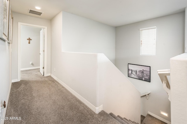 corridor with an upstairs landing, carpet, and baseboards