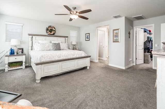 bedroom with light colored carpet, baseboards, a ceiling fan, and a spacious closet
