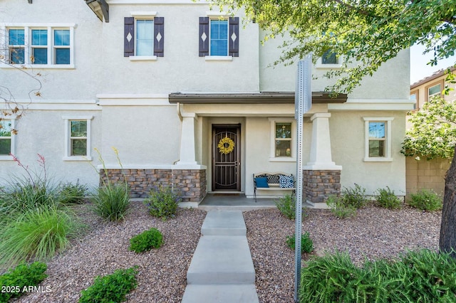 townhome / multi-family property featuring stone siding and stucco siding