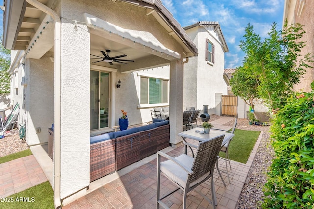 view of patio / terrace with an outdoor living space, a ceiling fan, and a gate