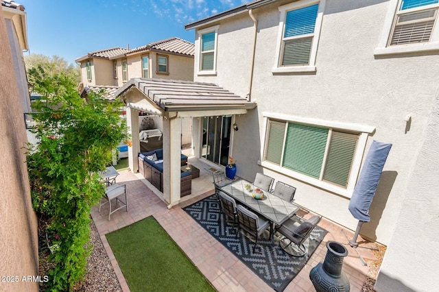 rear view of house with a patio, stucco siding, an outdoor hangout area, and outdoor dining space