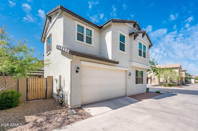 view of front of home with a garage, stucco siding, driveway, and a gate