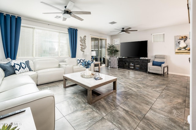living room featuring ceiling fan and baseboards