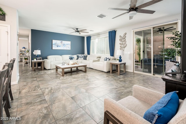 living room with a ceiling fan and baseboards