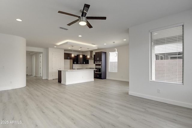 unfurnished living room featuring ceiling fan and light hardwood / wood-style floors