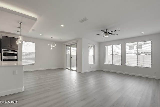 unfurnished living room featuring ceiling fan, plenty of natural light, and light wood-type flooring