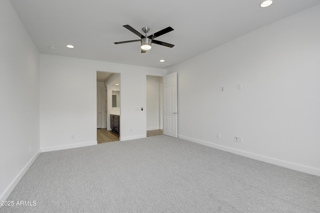 interior space with connected bathroom, light carpet, and ceiling fan