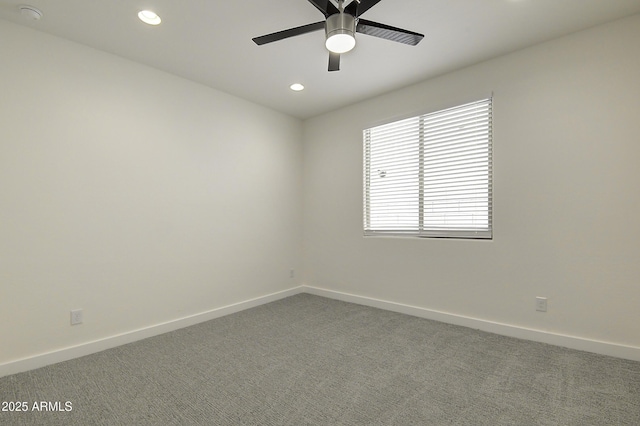 carpeted spare room featuring ceiling fan