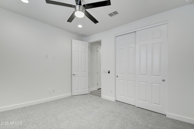 unfurnished bedroom featuring light colored carpet, ceiling fan, and a closet