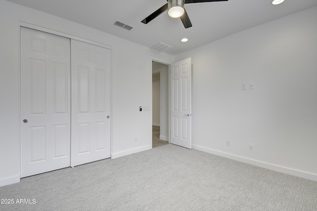 unfurnished bedroom featuring ceiling fan, a closet, and light carpet