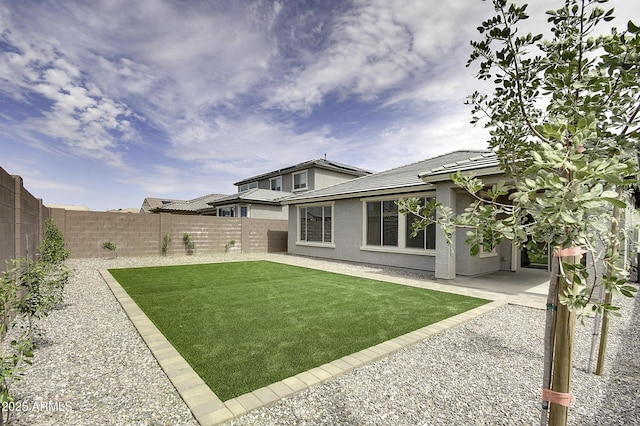 rear view of property featuring a lawn and a patio