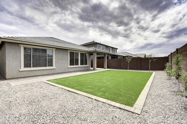 rear view of house featuring a lawn