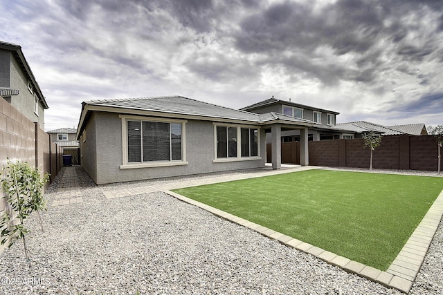 rear view of house featuring a patio area and a lawn