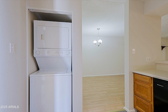 9355 N 91st St Unit 116, Scottsdale, AZ 85258 - washroom featuring stacked washer / drying machine, light wood finished floors, laundry area, baseboards, and a textured ceiling