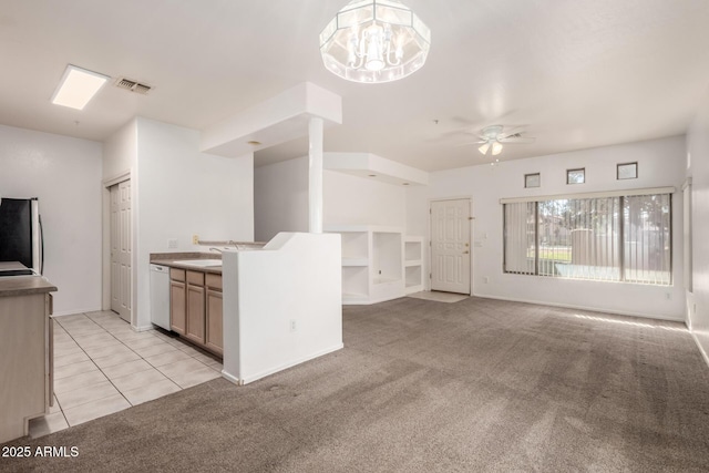 kitchen with decorative light fixtures, light carpet, stainless steel refrigerator, white dishwasher, and ceiling fan with notable chandelier