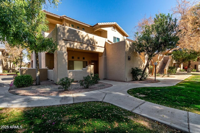 view of front of home with a balcony and a front lawn