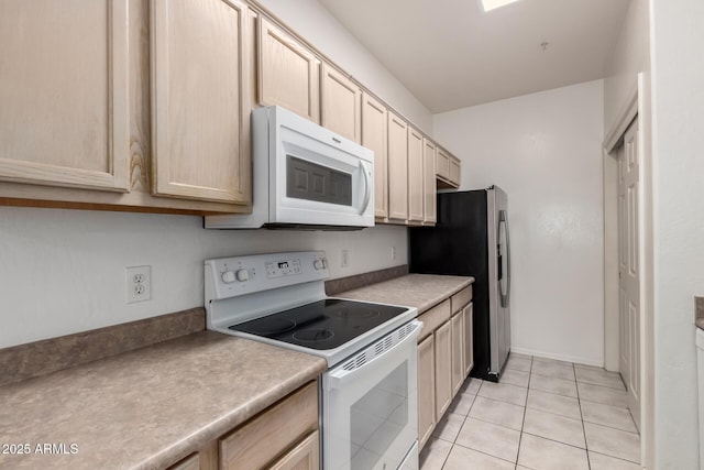 kitchen featuring white appliances, light brown cabinetry, and light tile patterned floors