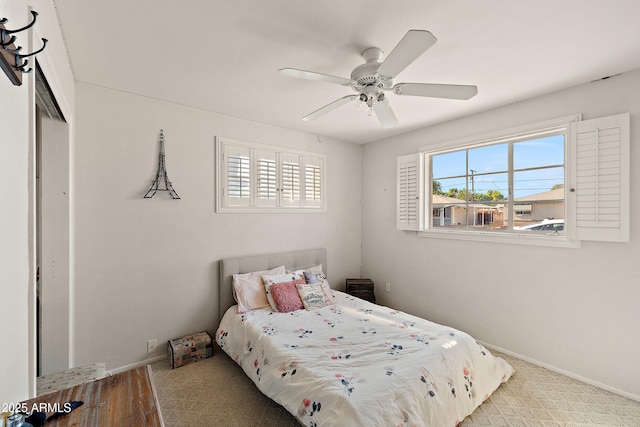 bedroom with ceiling fan, baseboards, and multiple windows