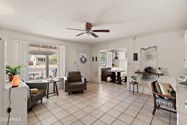 living room featuring baseboards, light tile patterned floors, and ceiling fan