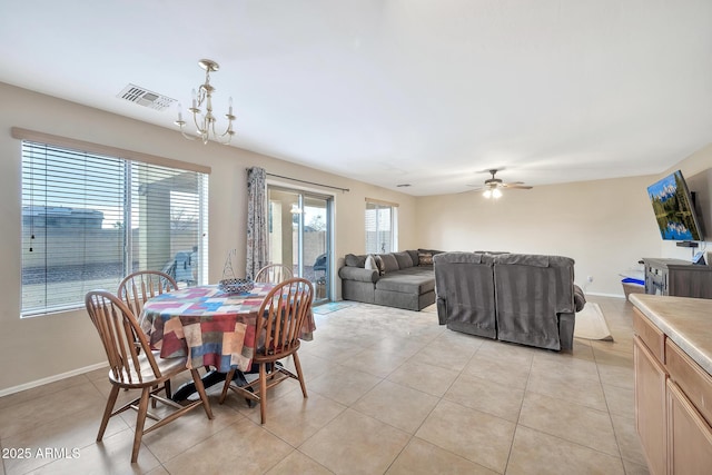 dining space featuring ceiling fan with notable chandelier and light tile patterned floors