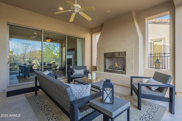 view of patio with ceiling fan and an outdoor living space with a fireplace