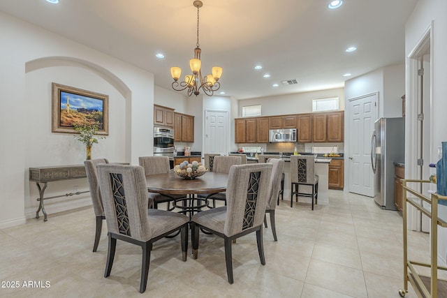 dining room with a chandelier and light tile patterned floors