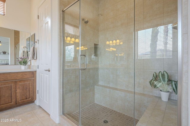 bathroom featuring vanity, a shower with door, tile patterned floors, and ceiling fan