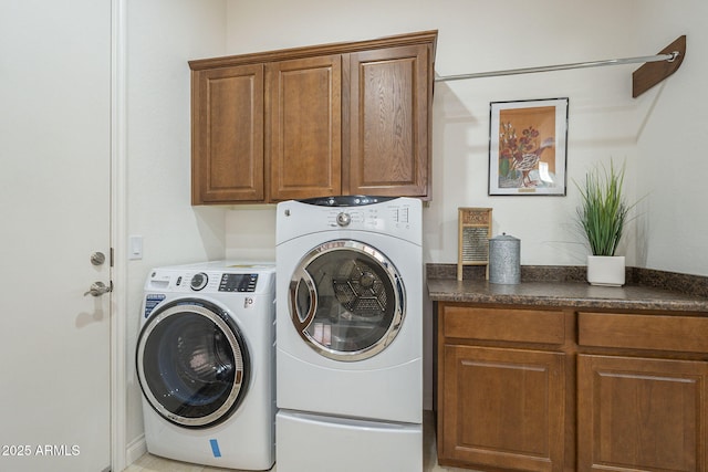 clothes washing area with cabinets and washer and clothes dryer