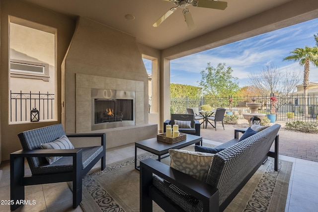 view of patio / terrace with ceiling fan and an outdoor living space with a fireplace