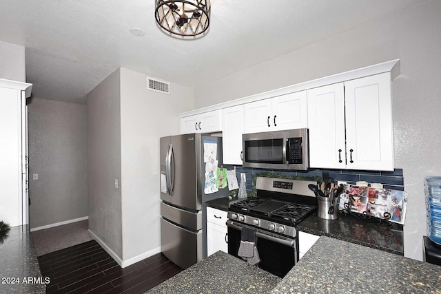 kitchen with tasteful backsplash, white cabinets, dark stone counters, and appliances with stainless steel finishes