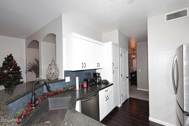 kitchen with dark stone countertops, white cabinetry, sink, and appliances with stainless steel finishes