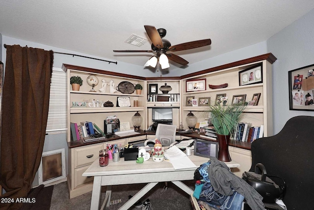 carpeted office space featuring ceiling fan and a textured ceiling