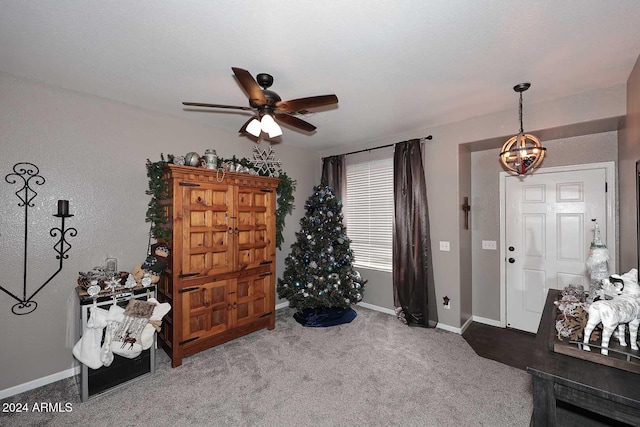 misc room featuring carpet floors and ceiling fan with notable chandelier