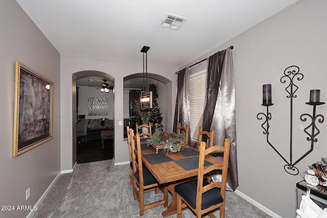 carpeted dining room with ceiling fan