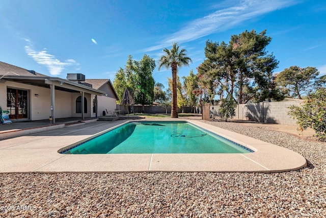 view of pool featuring a patio area, a fenced backyard, a fenced in pool, and central air condition unit