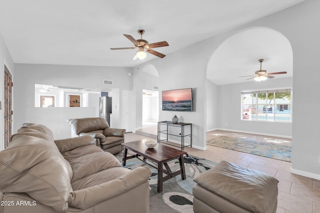 living room featuring light tile patterned floors, lofted ceiling, visible vents, and a ceiling fan