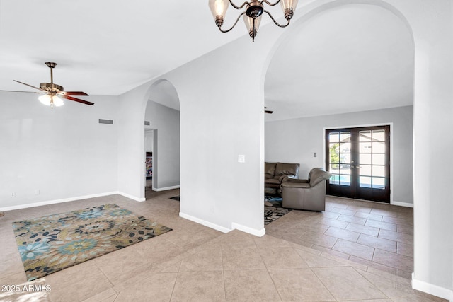 living room featuring visible vents, arched walkways, baseboards, lofted ceiling, and french doors