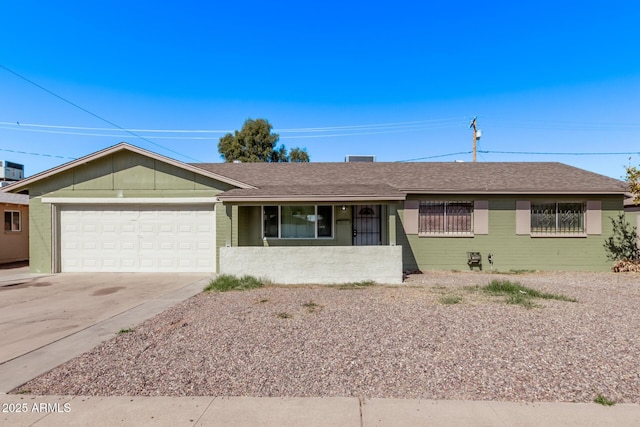 ranch-style house featuring an attached garage, driveway, roof with shingles, and covered porch