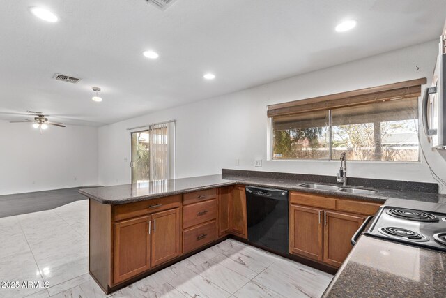 kitchen with black dishwasher, a sink, brown cabinets, a peninsula, and dark stone countertops