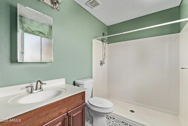 bathroom with toilet, a shower, and vanity
